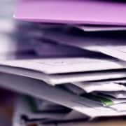 Pile de dossiers et documents illustrant la gestion confidentielle des données dans le secrétariat externalisé