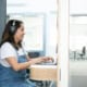 Secrétaire virtuelle concentrée, casque audio, relisant un document de transcription sur son écran d'ordinateur
