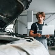 Expert automobile inspectant un véhicule endommagé chez un réparateur