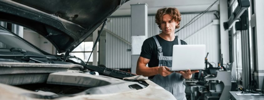 Expert automobile inspectant un véhicule endommagé chez un réparateur